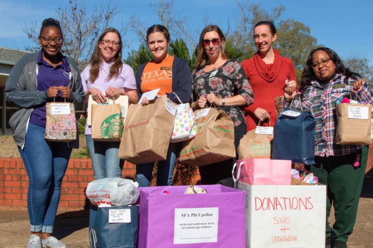 Sierra Smith, chapter president during the service project and recent SFA hospitality administration graduate from McKinney; Tracie Estepp, chapter vice president during the service project and SFA human sciences graduate student from Georgetown; and NISD social workers Lauren Ivy Sieja, Ashley Helmer, Catie Munguia and Kiesha Tutt sort through the donations in the fall before the COVID-19 pandemic. 