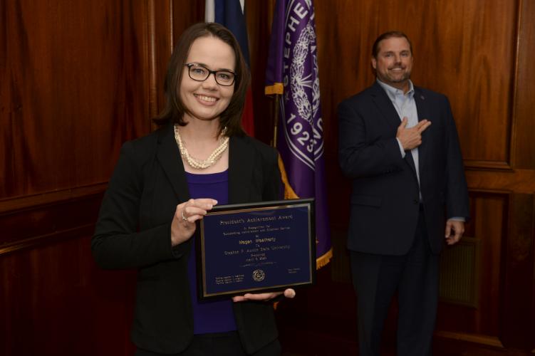 Megan Weatherly holding award plaque with President Scott Gordon standing in background