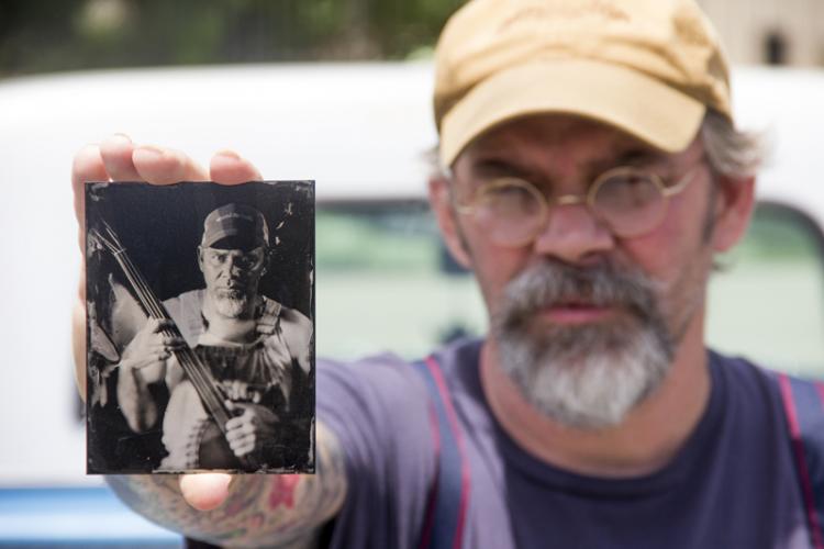 Ron King, SFA art instructor, holds a tintype portrait of himself.