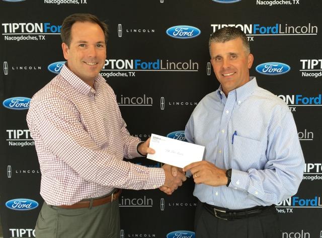 Dr. John Allen Hendricks, chair of the Stephen F. Austin State University Department of Mass Communication, left, accepts a check from Neal Slaten, president of Tipton Ford Lincoln of Nacogdoches
