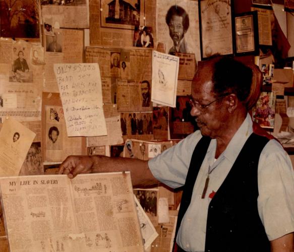 a photo of Nacogdoches leader the late Arthur Weaver holding up one of dozens of newspaper articles and clippings he saved during his decades-long fight advocating for civil rights