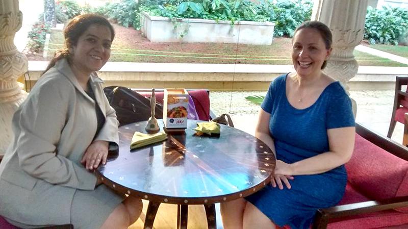 photo of Nandita Mehrotra sitting at a table with Heather Catton in Bangalore, India