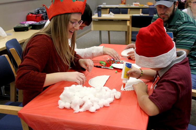 Laura Poynor helps a child build a Santa beard