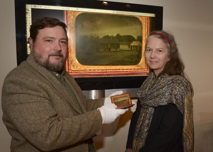 Michael Rugeley Moore showing the recently donated ambrotype of the stone house to Stone Fort Museum Director Carolyn Spears.