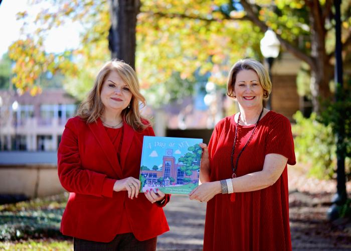 Dr. Shirley Luna, executive director of University Marketing Communications at Stephen F. Austin State University, and Donna Parish, assistant director, hold “A Day at SFA,” a new book they co-authored. 
