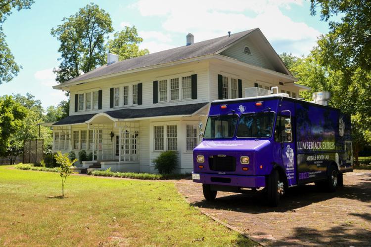 photo of the Lumberjack Express mobile food lab next to the future location of Culinary Café at 1401 Mound St., previously the home of former U.S. Sen. Kay Bailey Hutchison