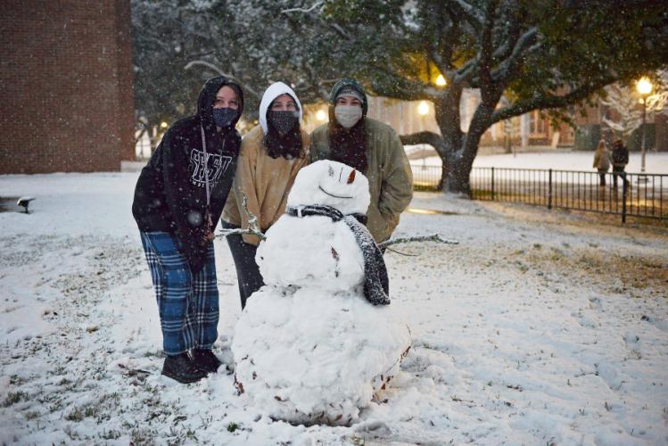 SFA students build a snowman.