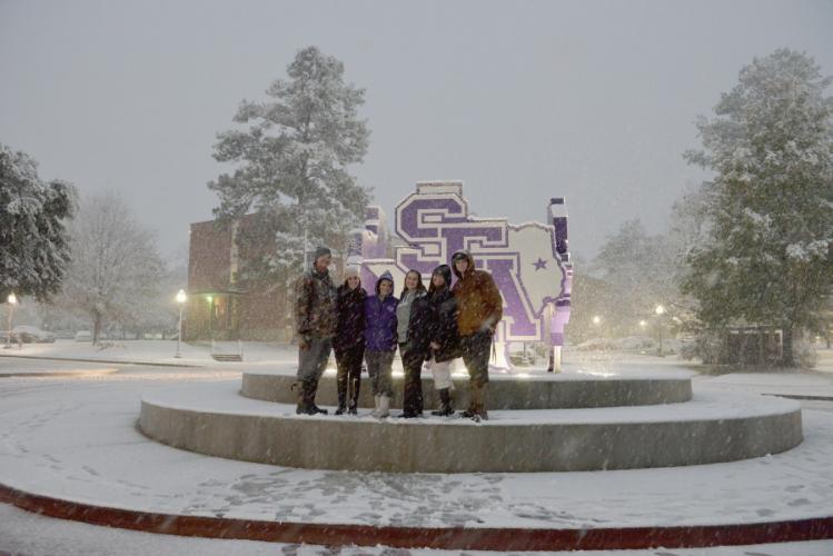 groupd of SFA students in front of SFA logos sign near the STEM Building