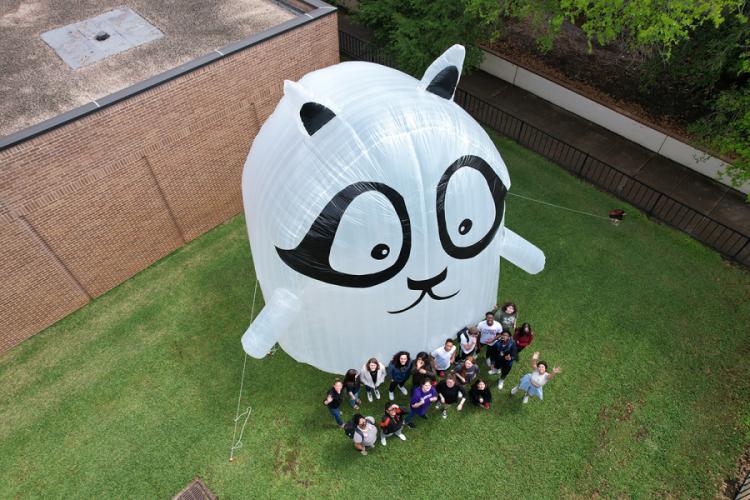 Students pose next to a large-scale inflatable