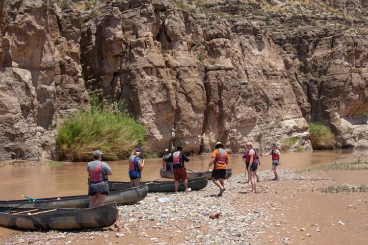 Students enjoy a photo stop during a canoe trip on the Rio Grande River