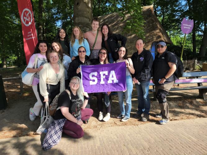 SFA students pose with an SFA banner while in the Netherlands