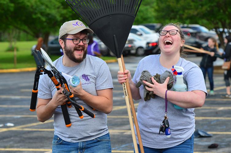 a pair of SFA students holding tools and laughing during The BIG Event