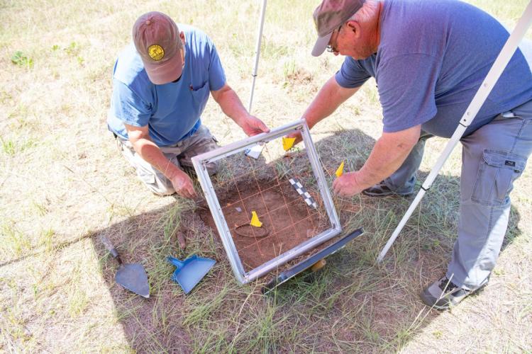 volunteers Keith Stephens and John Jefferson placing a grid over the test unit