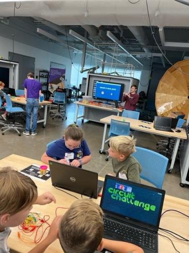 Little STEM Jacks campers work together to play the computer game SFA STEM Circuit Challenge.
