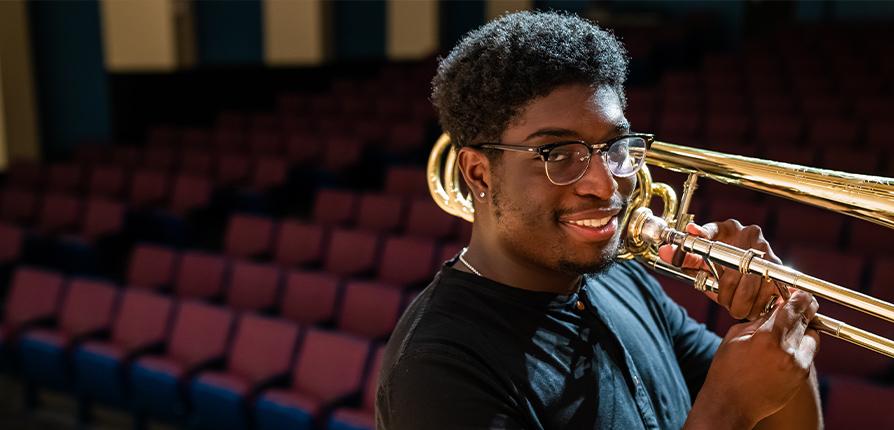 Student smiling with trombone