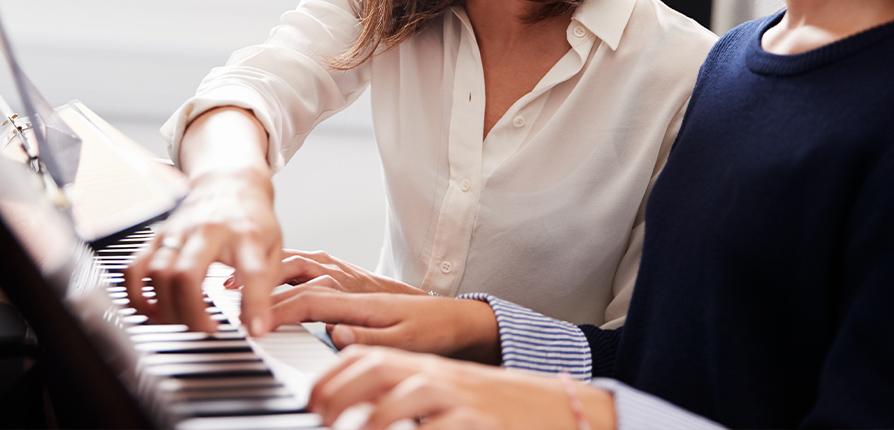 stock image of person teaching piano