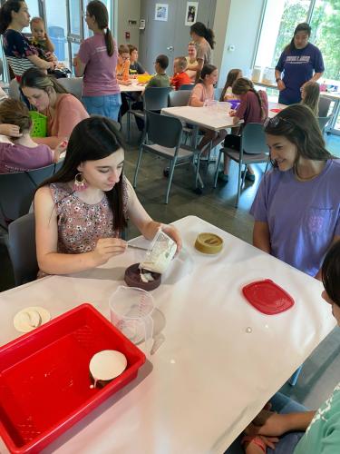 Participants pour plaster to create animal track casts during an environmental education event at Stephen F. Austin State University.