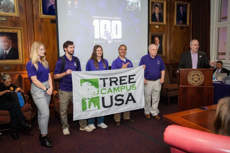 Arthur Temple College of Forestry and Agriculture Dean Hans Williams, forestry professor David Kulhavy, and forestry students Devin Stage, Miranda Cleveland, Christian Boser and Morgan Metcalf presented Stephen F. Austin State University’s Board of Regents with an Arbor Day banner at their meeting in April