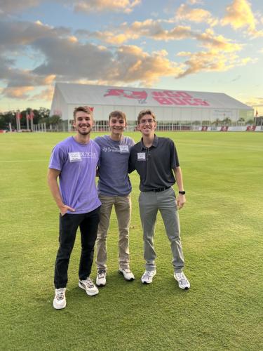 Matthew Morgan, a sports business senior from Allen; Eli Standley, a sports business junior from Warren; and Steven Luenser, a general business and marketing senior from Coppell, get ready to toss some balls and kick some field goals at the Tampa Bay Buccaneers’ practice field.