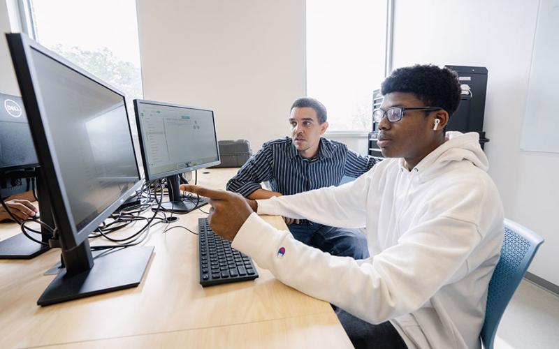 Student and professor working in computer lab