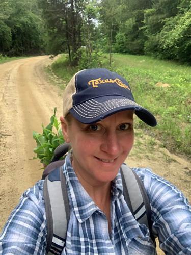 Dawn Stover is pictured walking down a wooded dirt road 