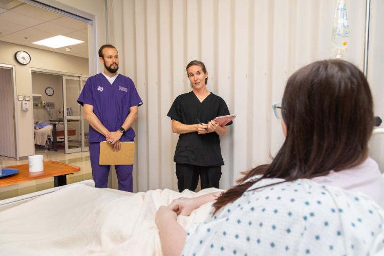    Justin Pelham, clinical instructor in James I. Perkins College of Education’s School of Human Sciences, acting as the clinical preceptor, while  nursing students role-play as patients who have Type 2 diabetes mellitus and have been hospitalized due to diabetic ketoacidosis; students also role-play dietetic specialists.