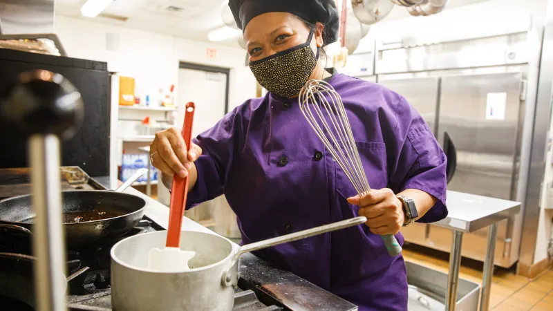 Student smiling while cooking