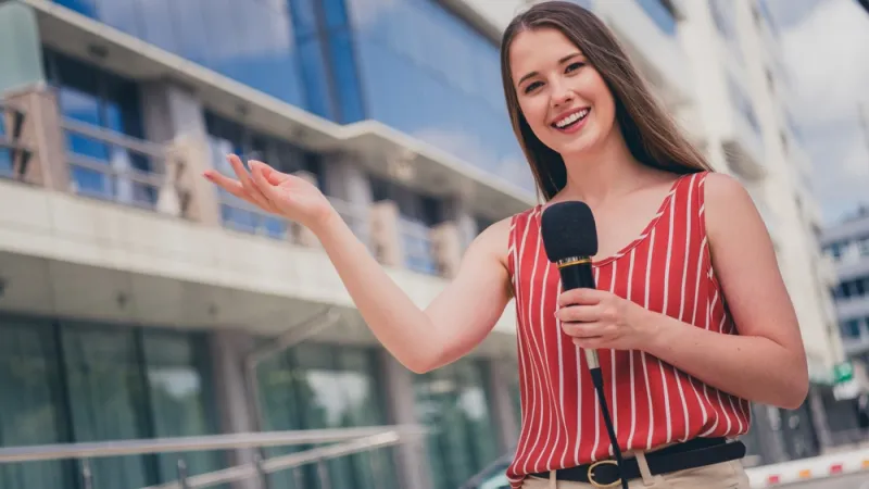 female journalist correspondent speaking in microphone television outdoors
