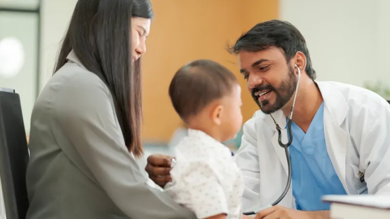 A kind doctor who treats pediatric patients. The child and his family brought him to see the doctor at the hospital because he was ill.