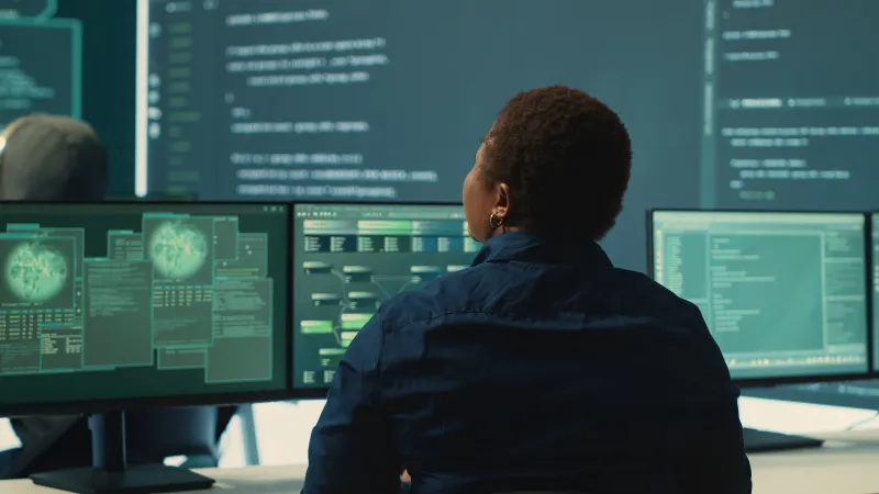 Governmental hackers analyzing big data for cyber threat detection, working at agency desks. Professional expert woman analyzes cyber intelligence and prevention of digital threats.