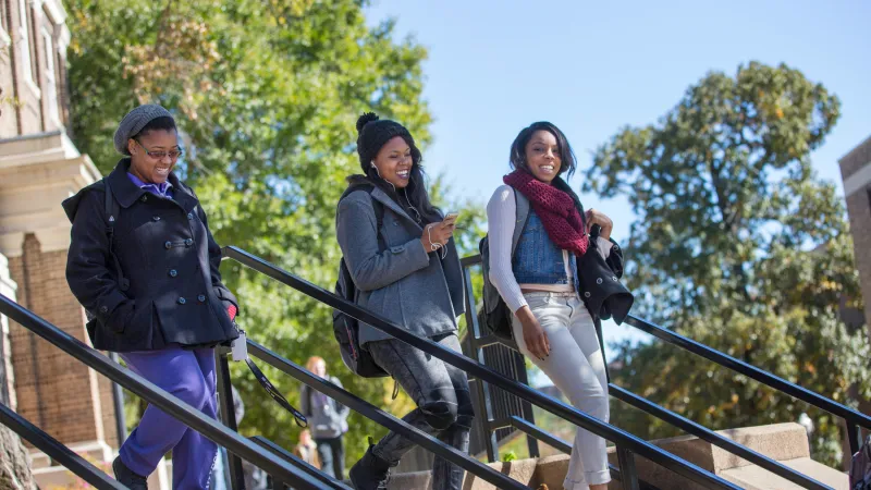 Three students walking in the shade