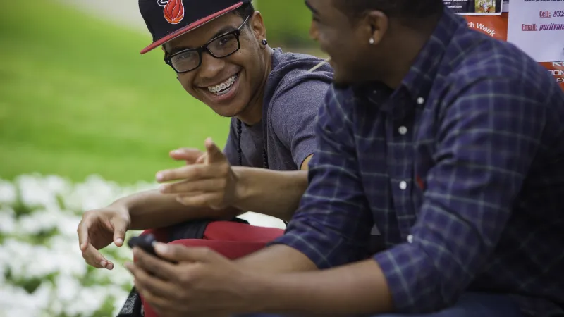 Student smiling at the camera while sitting outside
