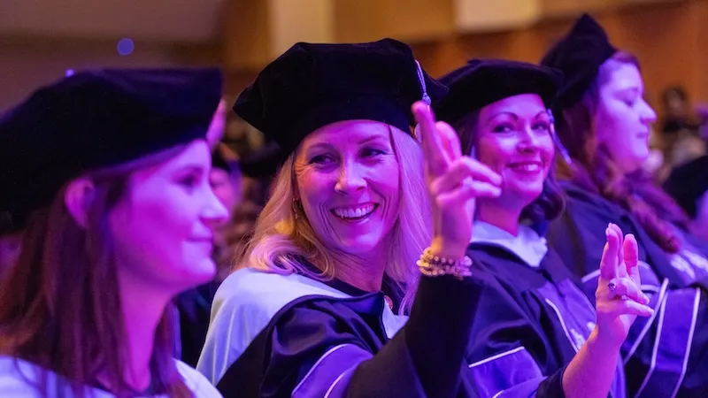 Students at the graduate ceremony with axes up