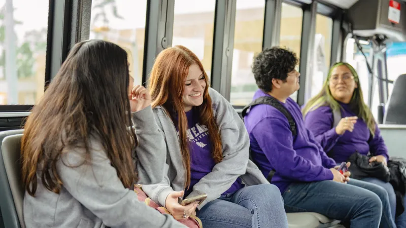 Students socializing while riding the campus bus