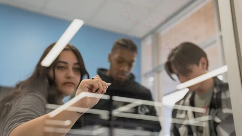 Students studying and using clear white board