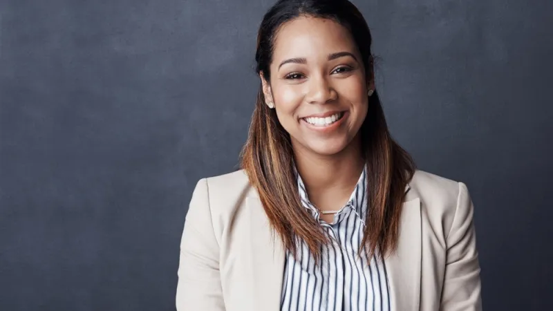 Woman professionally dressed smiling at the camera