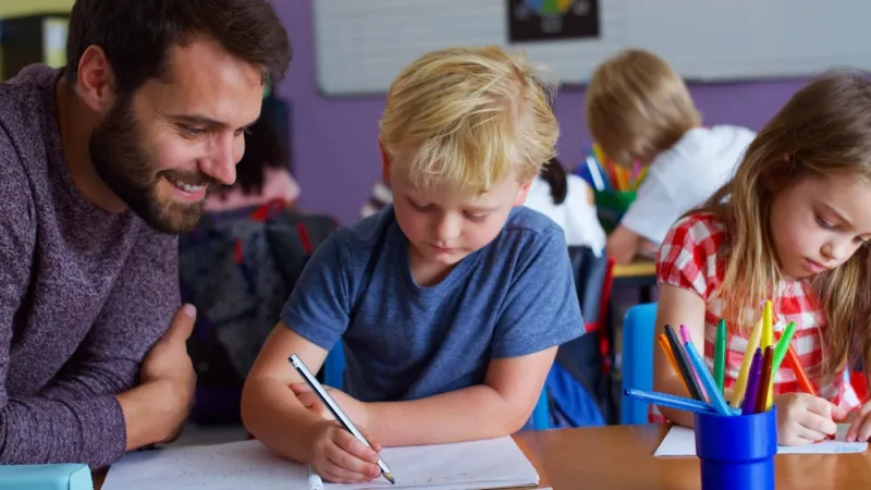 teacher helping early childhood student