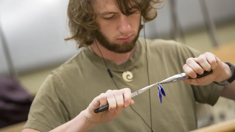 Student creating jewelry with pliers