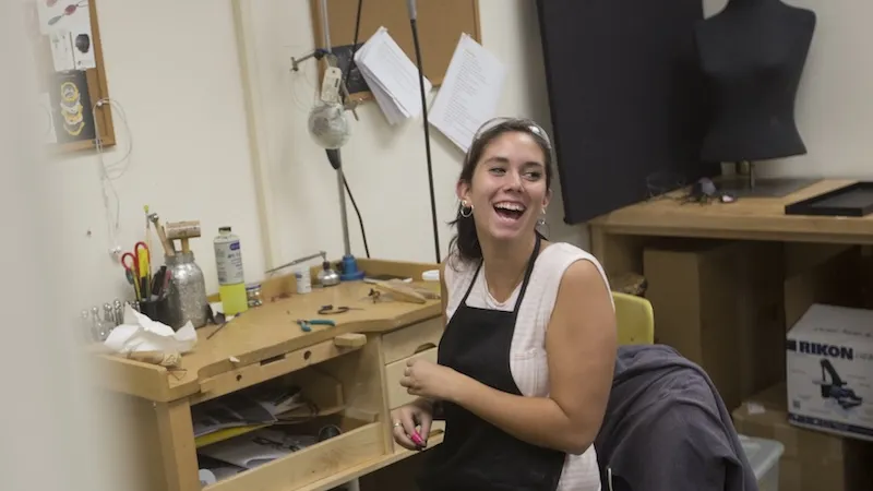 Student laughing while in the metals studio