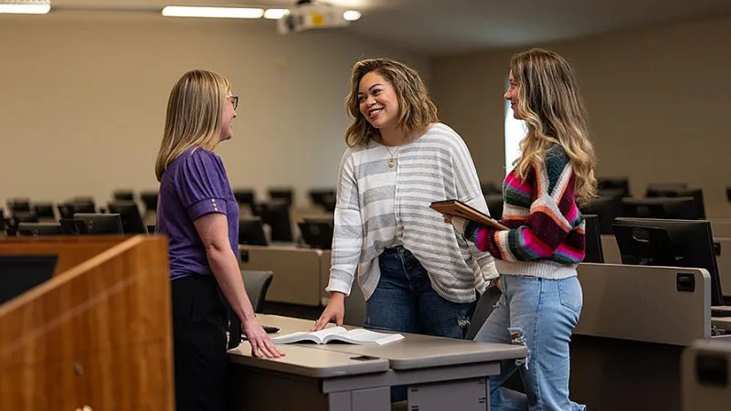 Students smiling and talking to instructor