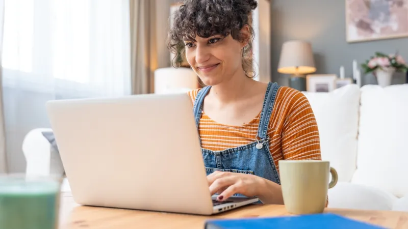 Young happy and confident woman using laptop computer at home