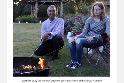 warming up by the fire with a student, Lauren Blackwell, at the annual Plant Fair