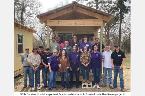 with Construction Management faculty and students in front of their tiny house project