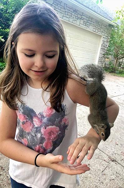 Bella Prunés enjoys her time with the baby squirrel. Though she lived with the family, the squirrel never became a permanent pet. Photo courtesy of DeAnna Prunés.