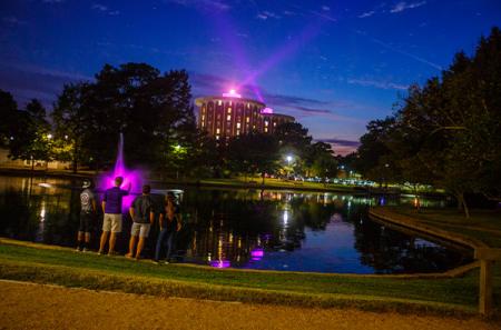 The Ag Pond with purple fountain and Steen Hall purple lights at dusk