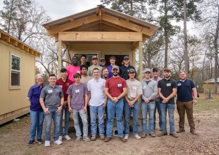 Construction Management students in front of one of the tiny homes they built.