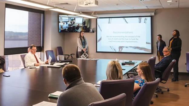 Students presenting in a boardroom