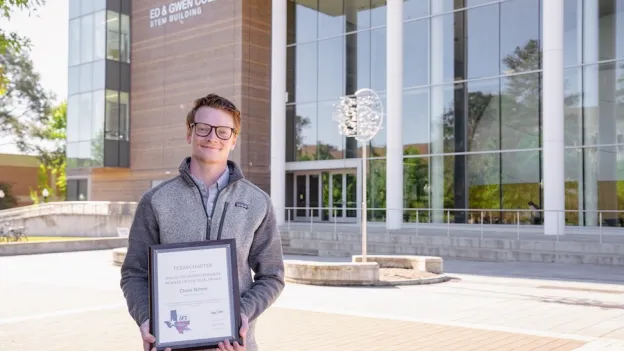 Biology student posing with award