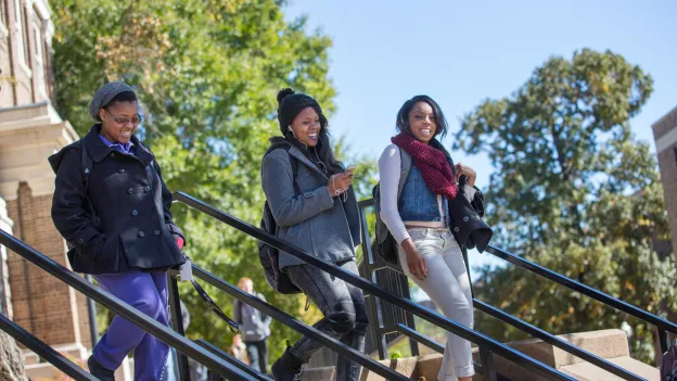 Three students walking in the shade