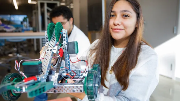 Student holding a mechanical robot